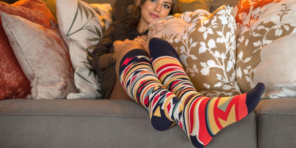 Woman wearing colorful wide leg socks on sofa