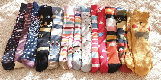 Colorful large socks on a cozy blanket in sunlight