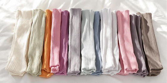 Colorful cotton knee-high socks arranged on white surface.