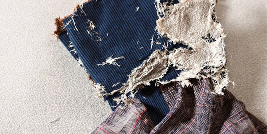 Close-up view of clearly ripped dress socks on textured background.
