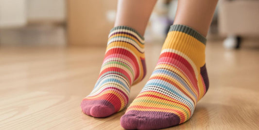 Women wearing colorful non slip socks indoors on wood floor.