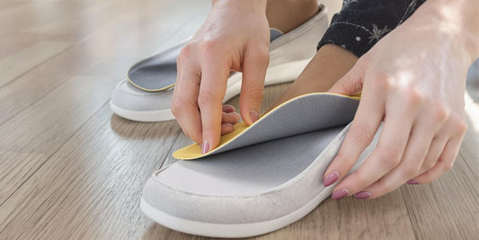 Woman putting cushioned insoles into stylish casual shoes