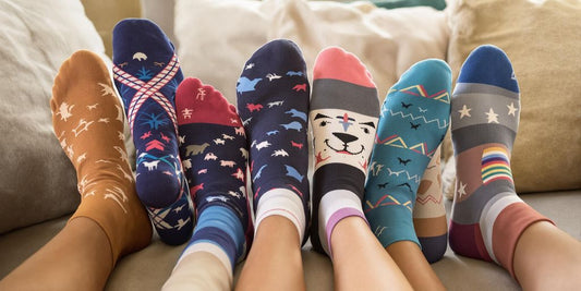 Group of feet in colorful unisex diabetic socks on couch